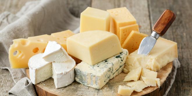 a board of various sliced cheeses