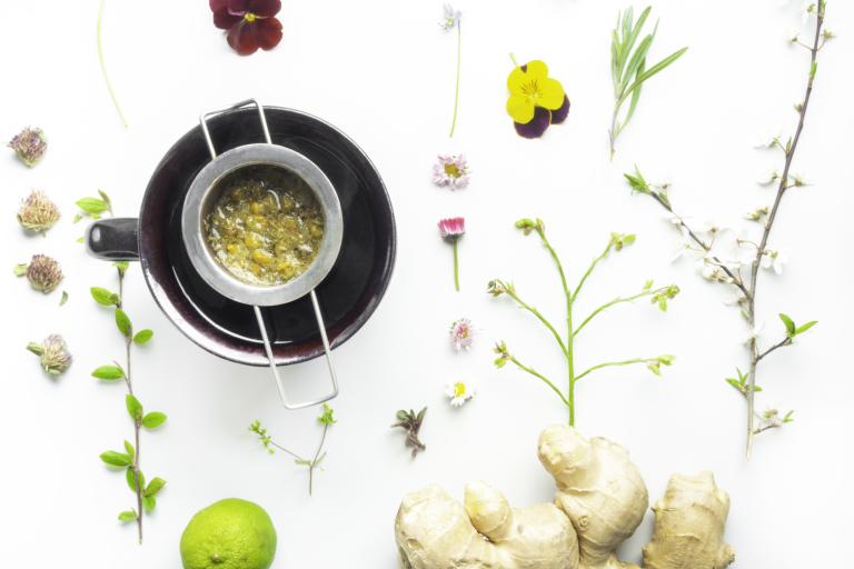 Tea cup with a diffuser over it filled with chopped ginger.